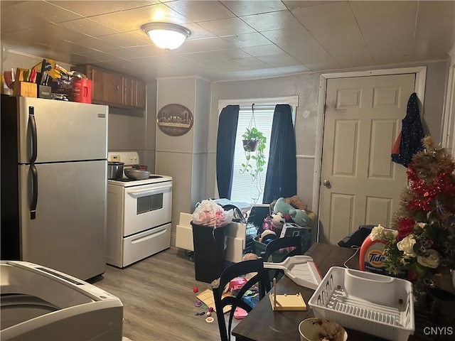 kitchen with light hardwood / wood-style flooring, stainless steel fridge, and white range with electric stovetop