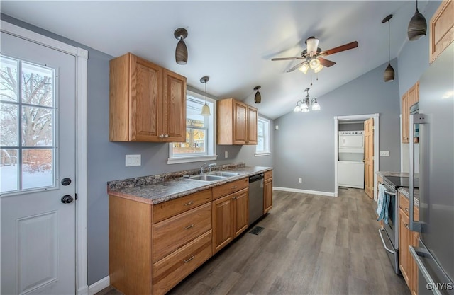 kitchen with appliances with stainless steel finishes, decorative light fixtures, vaulted ceiling, dark hardwood / wood-style flooring, and sink