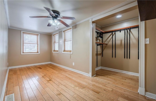 interior space with ornamental molding, ceiling fan, and light hardwood / wood-style floors