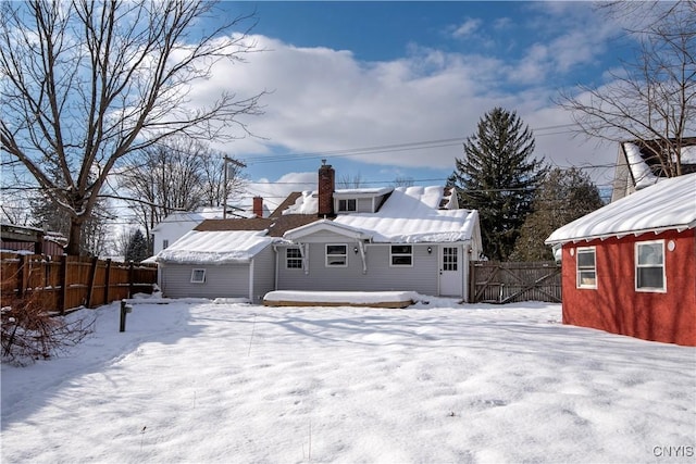 snow covered property with an outbuilding