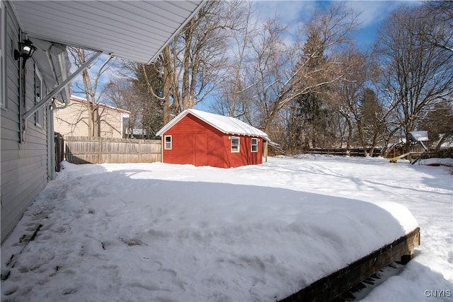 yard covered in snow with a storage shed