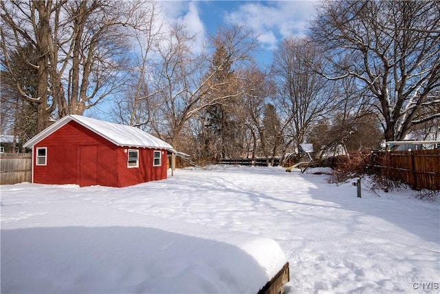 snowy yard featuring an outbuilding