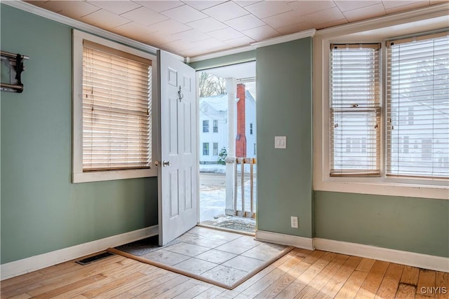 entryway featuring a healthy amount of sunlight, light hardwood / wood-style flooring, and crown molding