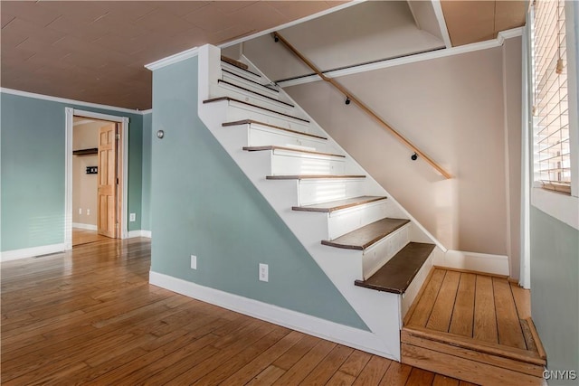 stairs featuring ornamental molding and wood-type flooring