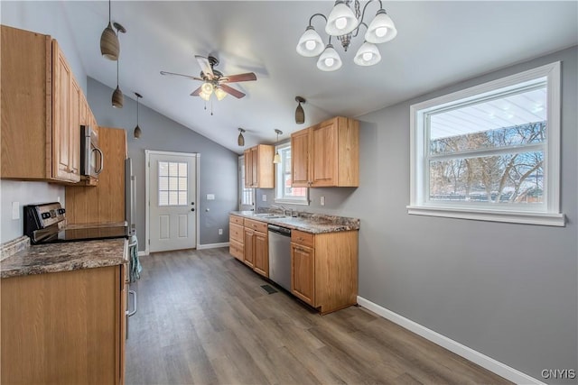 kitchen featuring appliances with stainless steel finishes, decorative light fixtures, ceiling fan with notable chandelier, lofted ceiling, and light hardwood / wood-style floors