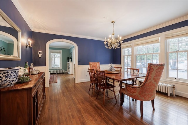 dining space with dark wood-type flooring, crown molding, radiator, and a chandelier