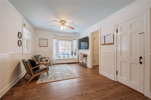 sitting room featuring crown molding, ceiling fan, radiator heating unit, and dark hardwood / wood-style flooring