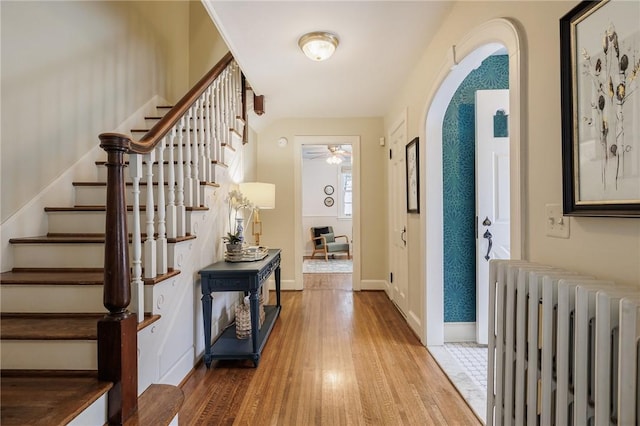 foyer with ceiling fan, wood-type flooring, and radiator