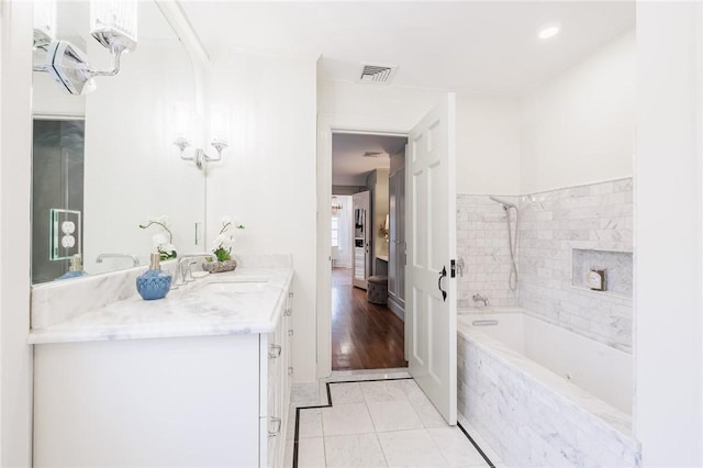 bathroom featuring tiled shower / bath, vanity, and tile patterned floors