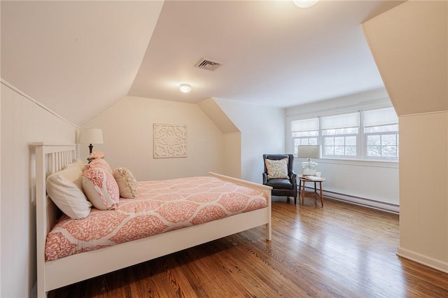 bedroom with baseboard heating, lofted ceiling, and wood-type flooring