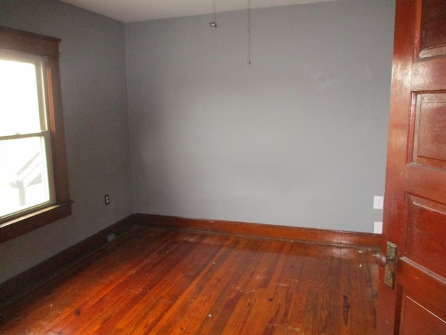 unfurnished room with dark wood-type flooring and a healthy amount of sunlight