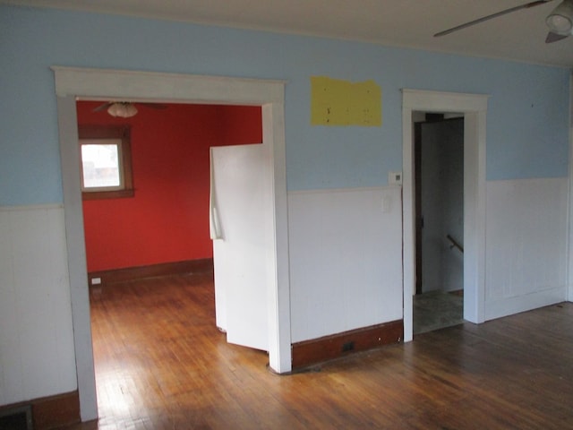 spare room with dark hardwood / wood-style flooring and ceiling fan