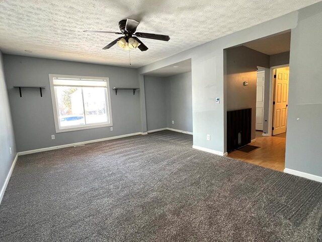 carpeted empty room featuring a textured ceiling and ceiling fan