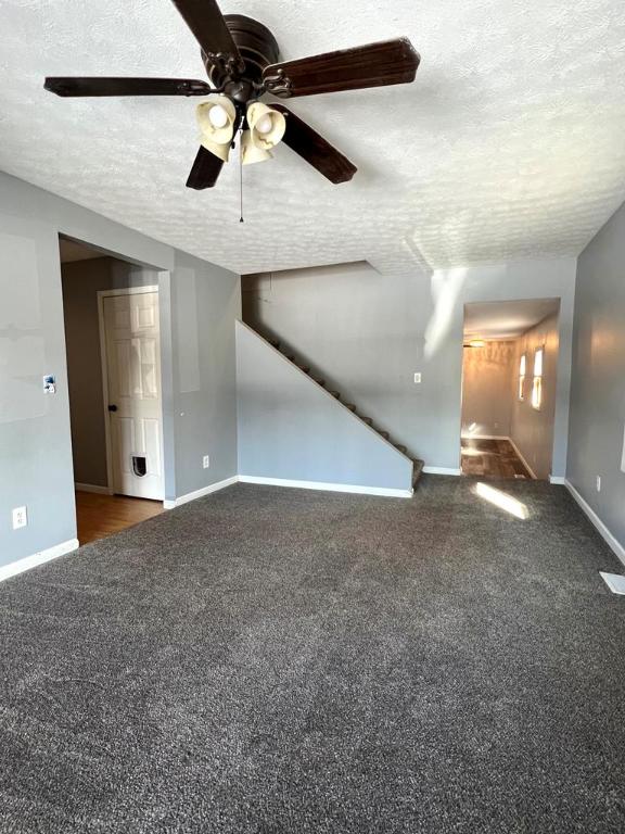 576 W High St, Erwin, NY 14870 - unfurnished living room featuring baseboards, a textured ceiling, and carpet