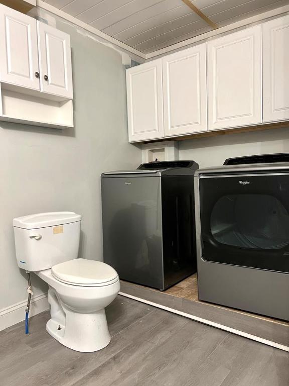 washroom featuring separate washer and dryer, dark hardwood / wood-style floors, and wooden ceiling