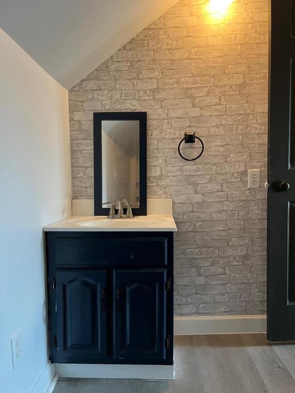 576 W High St, Erwin, NY 14870 - bathroom featuring lofted ceiling, wood finished floors, vanity, and baseboards