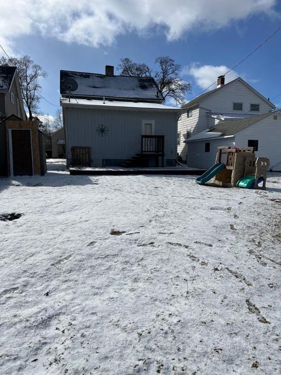 snow covered property featuring a playground