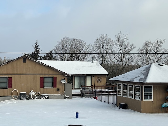 snow covered rear of property with cooling unit