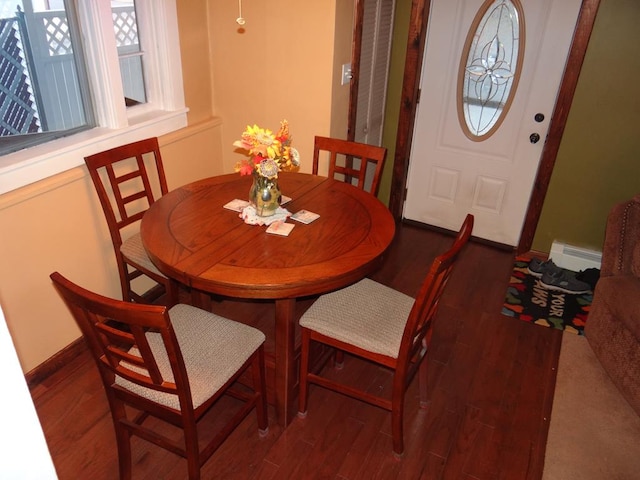 dining room with a baseboard heating unit and dark hardwood / wood-style floors