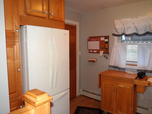 kitchen featuring white refrigerator, a baseboard radiator, and light wood-type flooring