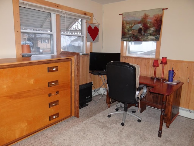 carpeted home office with wood walls and a wealth of natural light