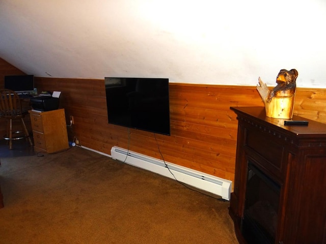 interior space featuring a baseboard radiator, lofted ceiling, dark carpet, and wooden walls