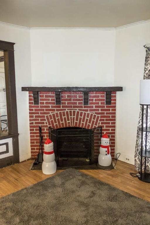 details featuring hardwood / wood-style flooring, ornamental molding, and a brick fireplace