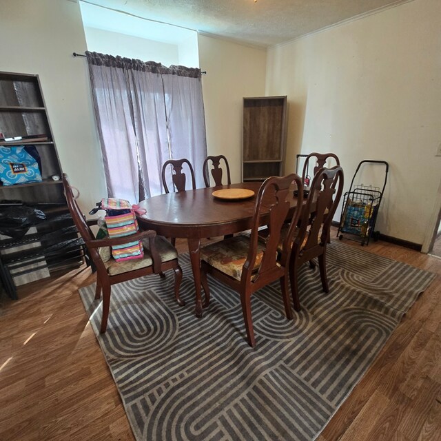 dining space featuring a textured ceiling and hardwood / wood-style flooring