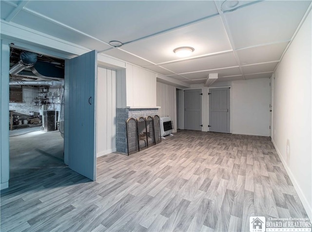 basement with heating unit and light wood-type flooring