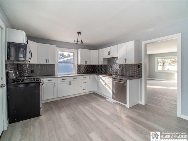 kitchen featuring tasteful backsplash, appliances with stainless steel finishes, light hardwood / wood-style floors, and white cabinets