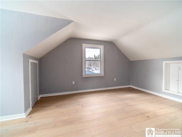 bonus room featuring vaulted ceiling and light hardwood / wood-style flooring