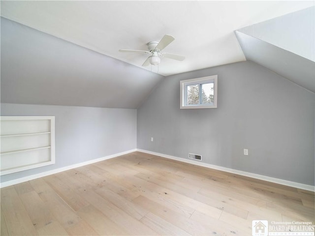 additional living space featuring vaulted ceiling, ceiling fan, light hardwood / wood-style floors, and built in features