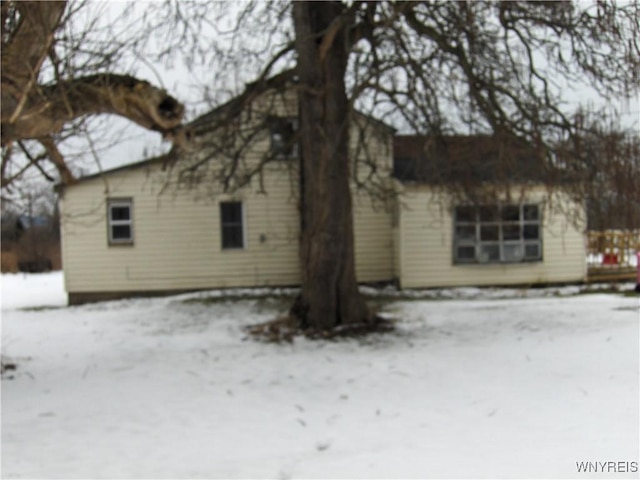 view of snow covered back of property