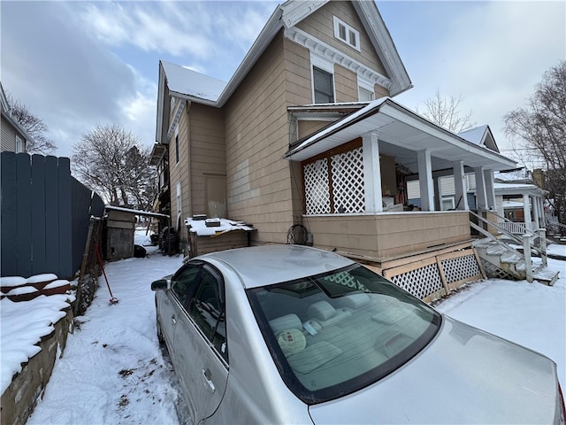 view of snow covered exterior featuring a porch