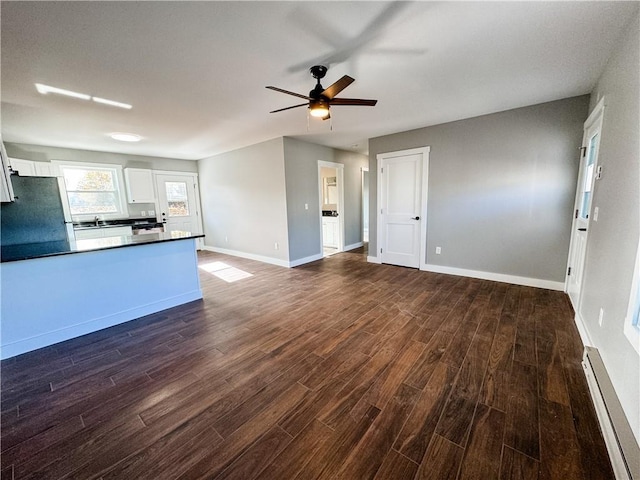 kitchen with white cabinetry, stainless steel fridge, dark hardwood / wood-style flooring, a baseboard heating unit, and ceiling fan