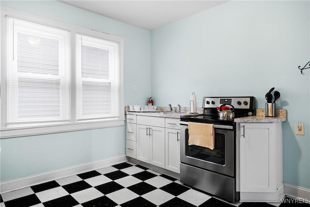 kitchen with white cabinetry, sink, and stainless steel range with electric cooktop