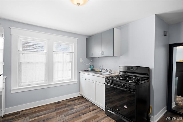 kitchen with dark wood-type flooring, gray cabinets, black gas stove, and sink