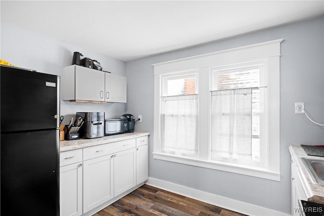 kitchen with dark wood-type flooring, sink, white cabinets, and black appliances