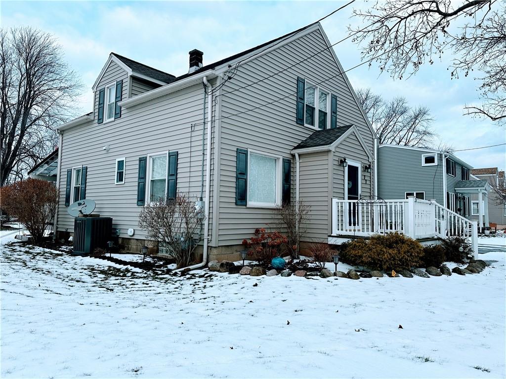 snow covered house with a wooden deck and central air condition unit