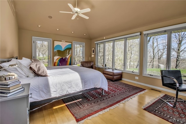 bedroom with lofted ceiling, access to exterior, and hardwood / wood-style floors