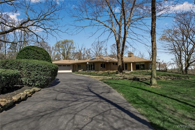 ranch-style home with a garage and a front yard