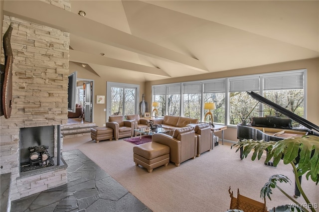 living room with carpet flooring, high vaulted ceiling, a stone fireplace, and a wealth of natural light