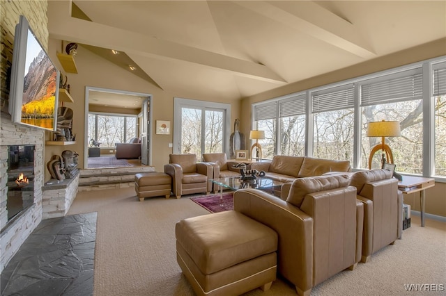 living room featuring a stone fireplace, high vaulted ceiling, and carpet