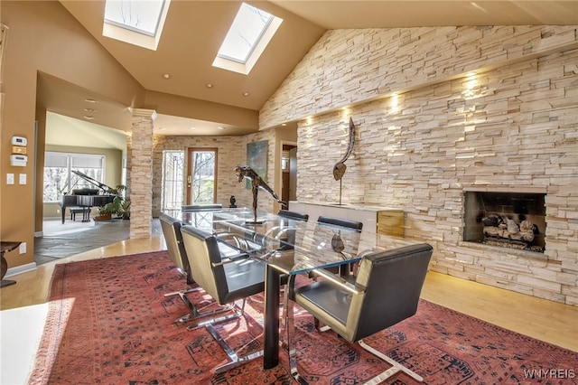 dining area with decorative columns, wood-type flooring, and high vaulted ceiling