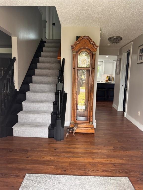 staircase featuring hardwood / wood-style floors and a textured ceiling