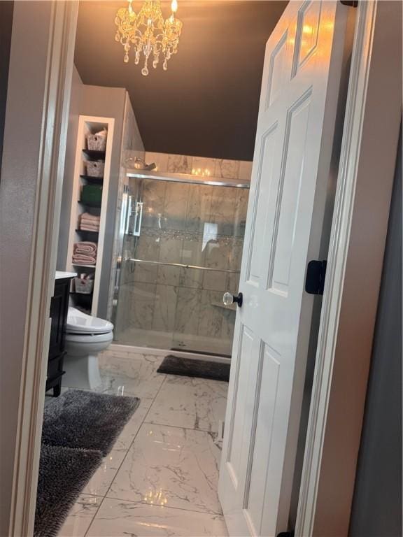 bathroom with a notable chandelier, vanity, an enclosed shower, and toilet