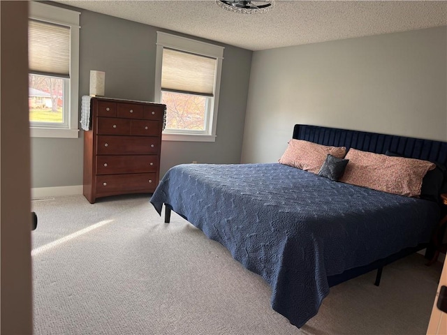 bedroom featuring light carpet and a textured ceiling