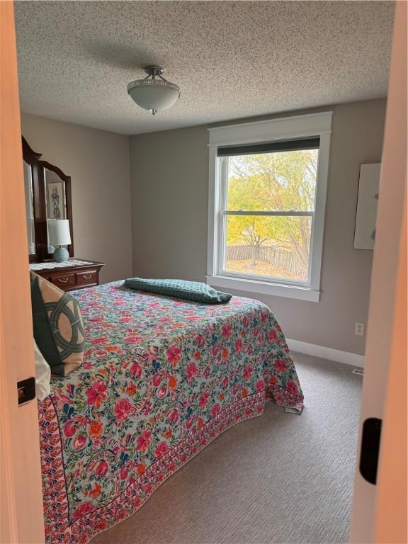 bedroom with carpet flooring and a textured ceiling