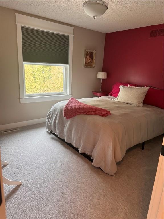 carpeted bedroom featuring a textured ceiling