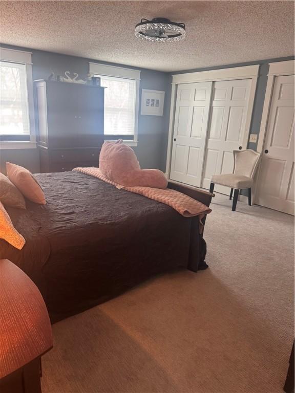 bedroom with carpet floors and a textured ceiling